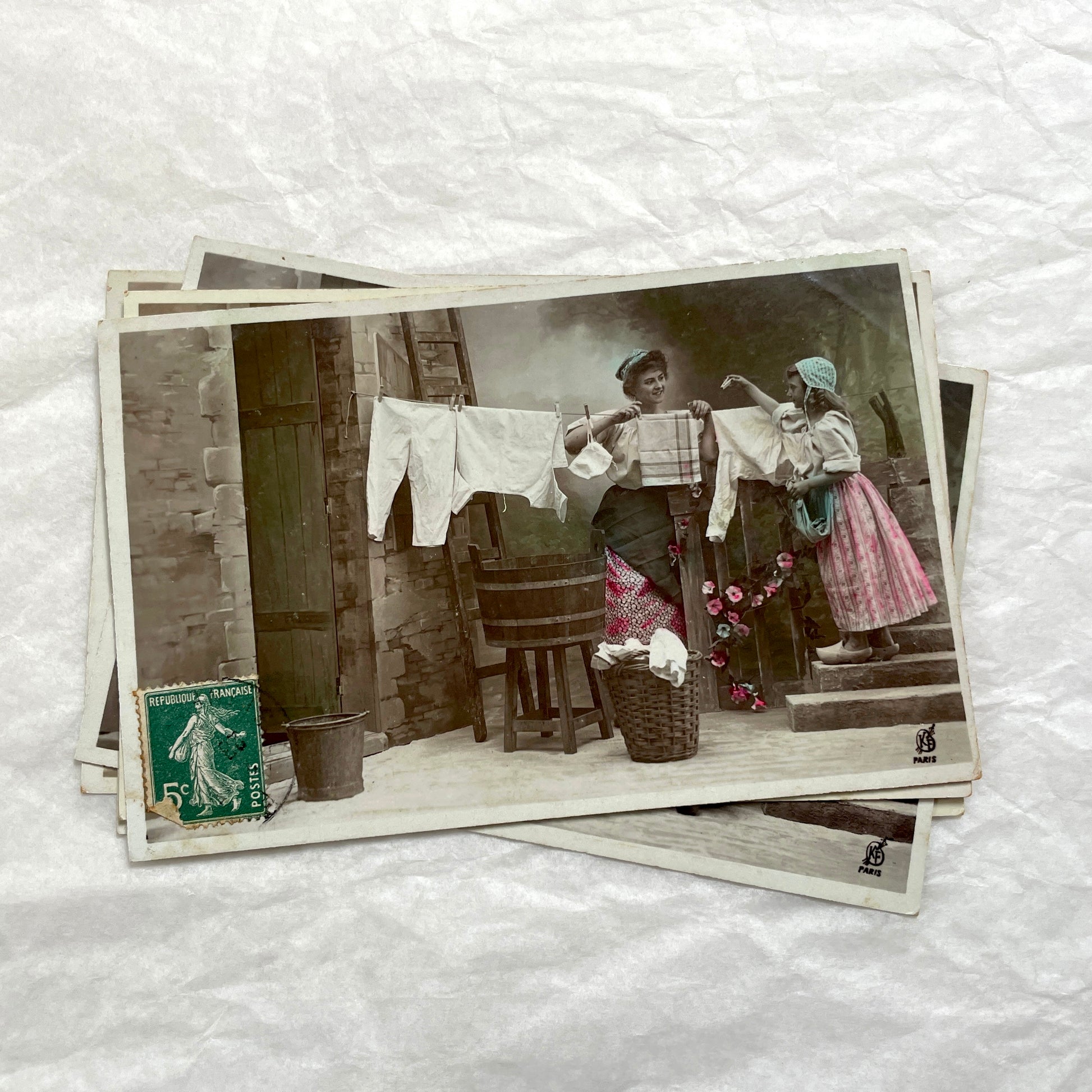 Lot of 6 1910s French postcards depicting women washing laundry in a village setting with visible French stamps.