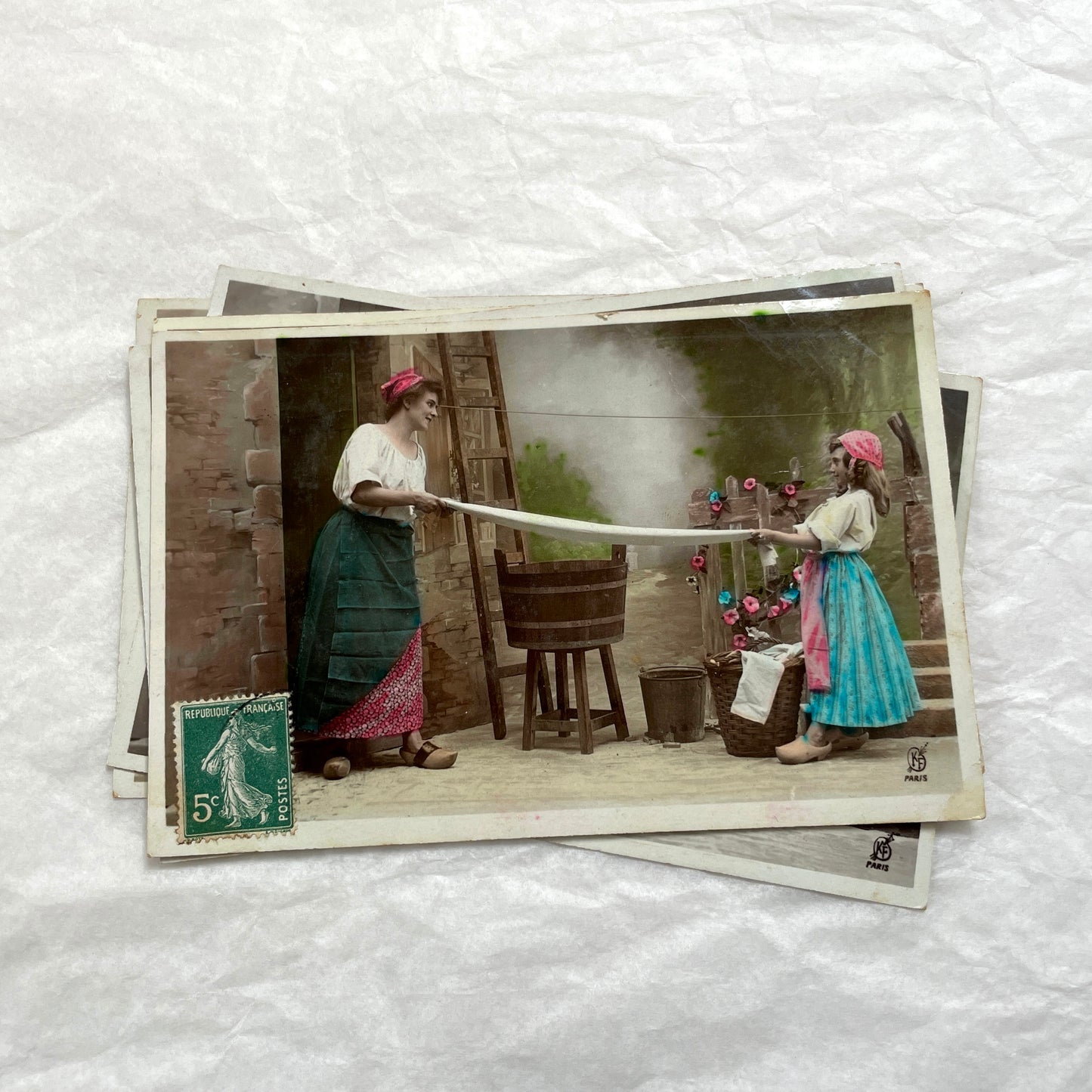 Lot of 6 1910s French postcards depicting women washing laundry in a village setting with visible French stamps.