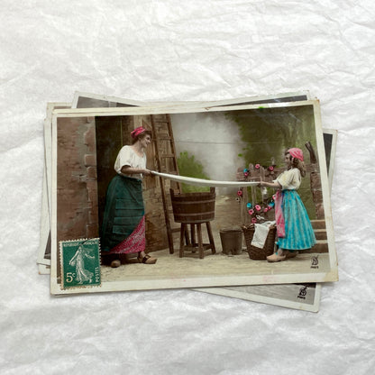 Lot of 6 1910s French postcards depicting women washing laundry in a village setting with visible French stamps.
