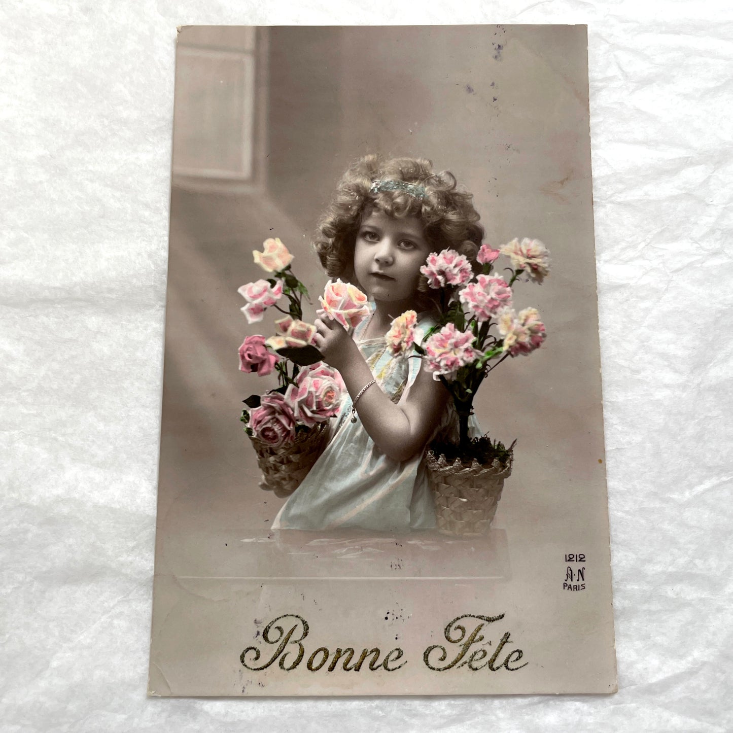 Two French postcards from the 1910s depicting young girls with flowers and 'Bonne Fete' greetings.