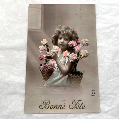 Two French postcards from the 1910s depicting young girls with flowers and 'Bonne Fete' greetings.