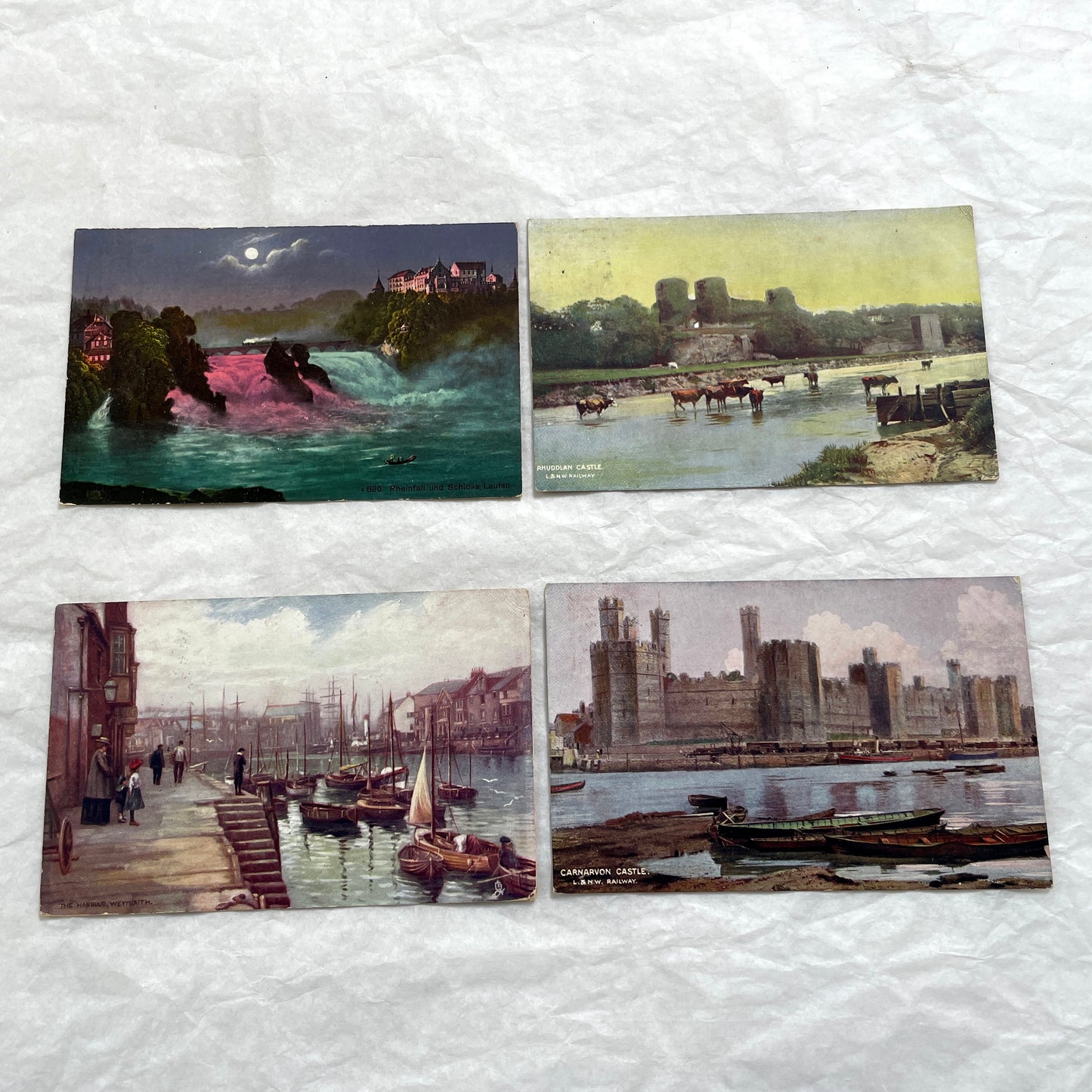 1910s postcard lot featuring European castles, a Swiss waterfall, and an English harbor scene with boats.