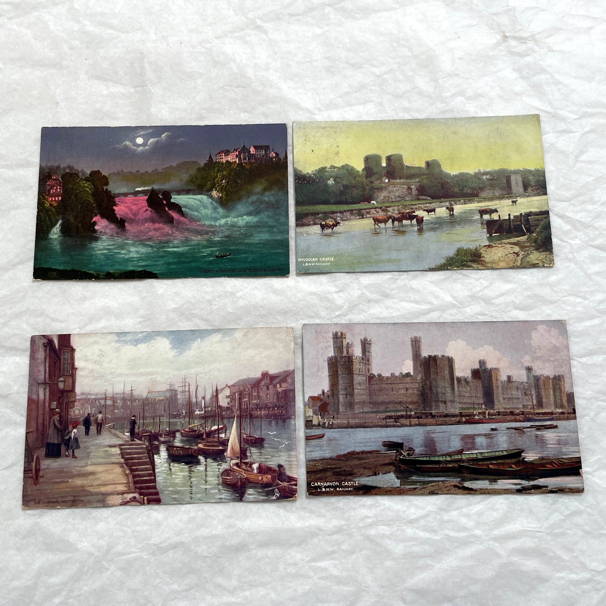 1910s postcard lot featuring European castles, a Swiss waterfall, and an English harbor scene with boats.