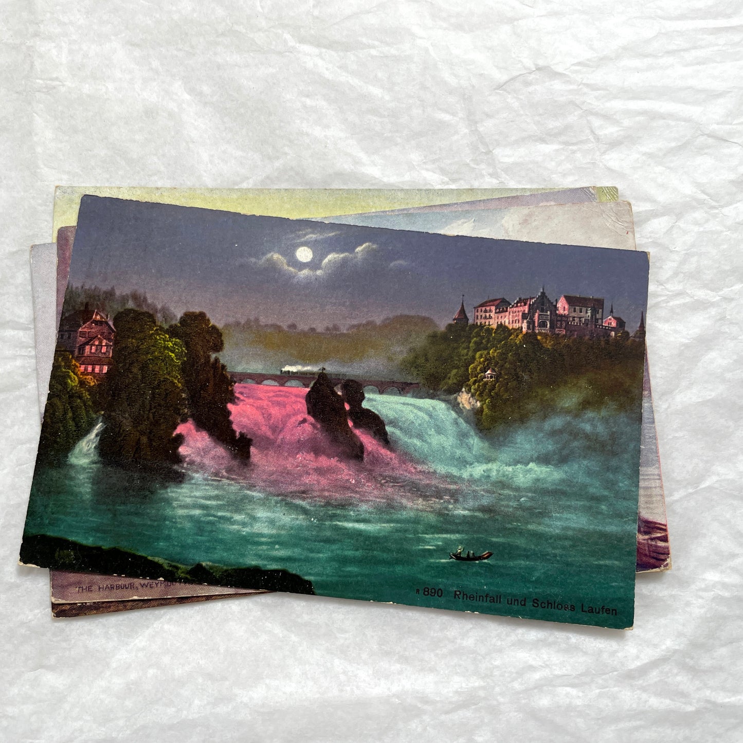 1910s postcard lot featuring European castles, a Swiss waterfall, and an English harbor scene with boats.