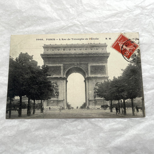 1900s postcard of Paris Arc de Triomphe with horse carriages and pedestrians on a tree-lined street.