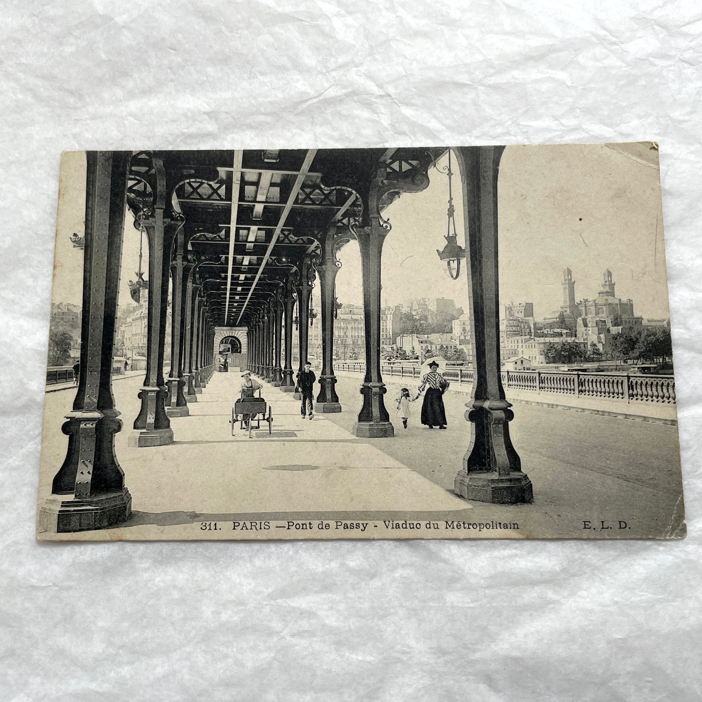 1900s Paris postcard of Pont de Passy Métro viaduct with pedestrians, showing historical Parisian architecture.