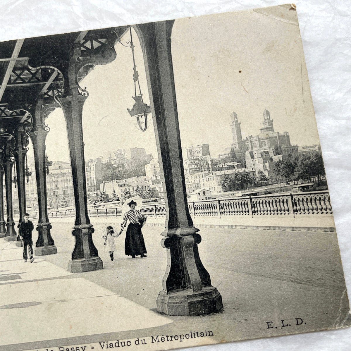 1900s Paris postcard of Pont de Passy Métro viaduct with pedestrians, showing historical Parisian architecture.
