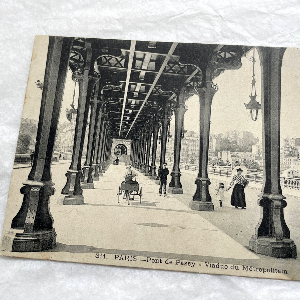 1900s Paris postcard of Pont de Passy Métro viaduct with pedestrians, showing historical Parisian architecture.