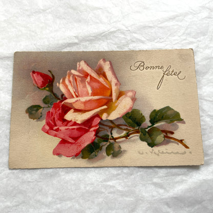 1910s French postcard with an illustration of pink and red roses and 'Bonne fête!' script.