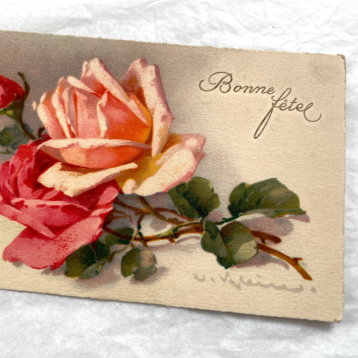 1910s French postcard with an illustration of pink and red roses and 'Bonne fête!' script.
