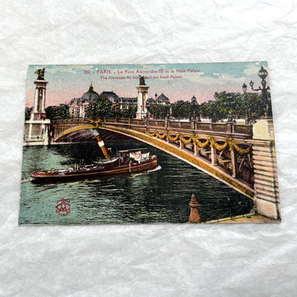 1900s vintage Paris postcards showing Pont Alexandre III and Conciergerie with boats on the Seine River.