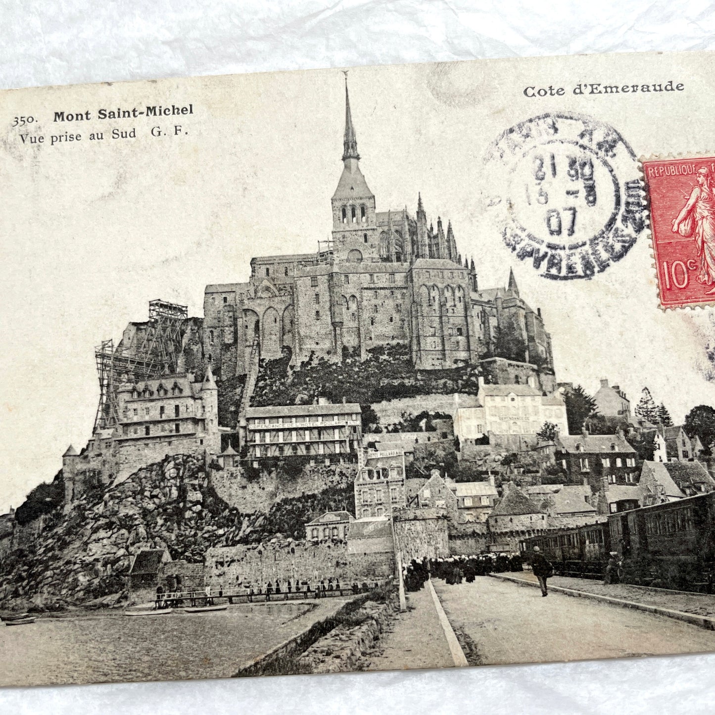 1900s postcard of Mont Saint-Michel abbey in France, showing its majestic medieval architecture and surrounding village.