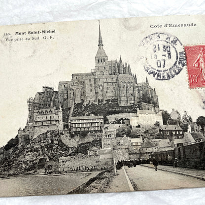 1900s postcard of Mont Saint-Michel abbey in France, showing its majestic medieval architecture and surrounding village.