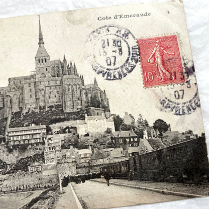 1900s postcard of Mont Saint-Michel abbey in France, showing its majestic medieval architecture and surrounding village.