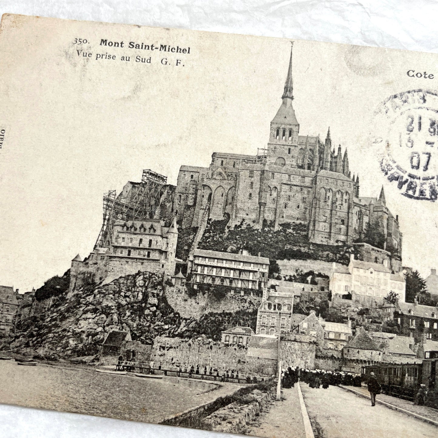 1900s postcard of Mont Saint-Michel abbey in France, showing its majestic medieval architecture and surrounding village.