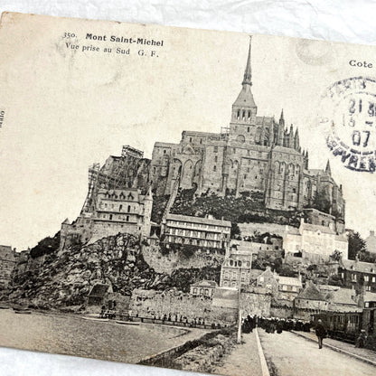 1900s postcard of Mont Saint-Michel abbey in France, showing its majestic medieval architecture and surrounding village.