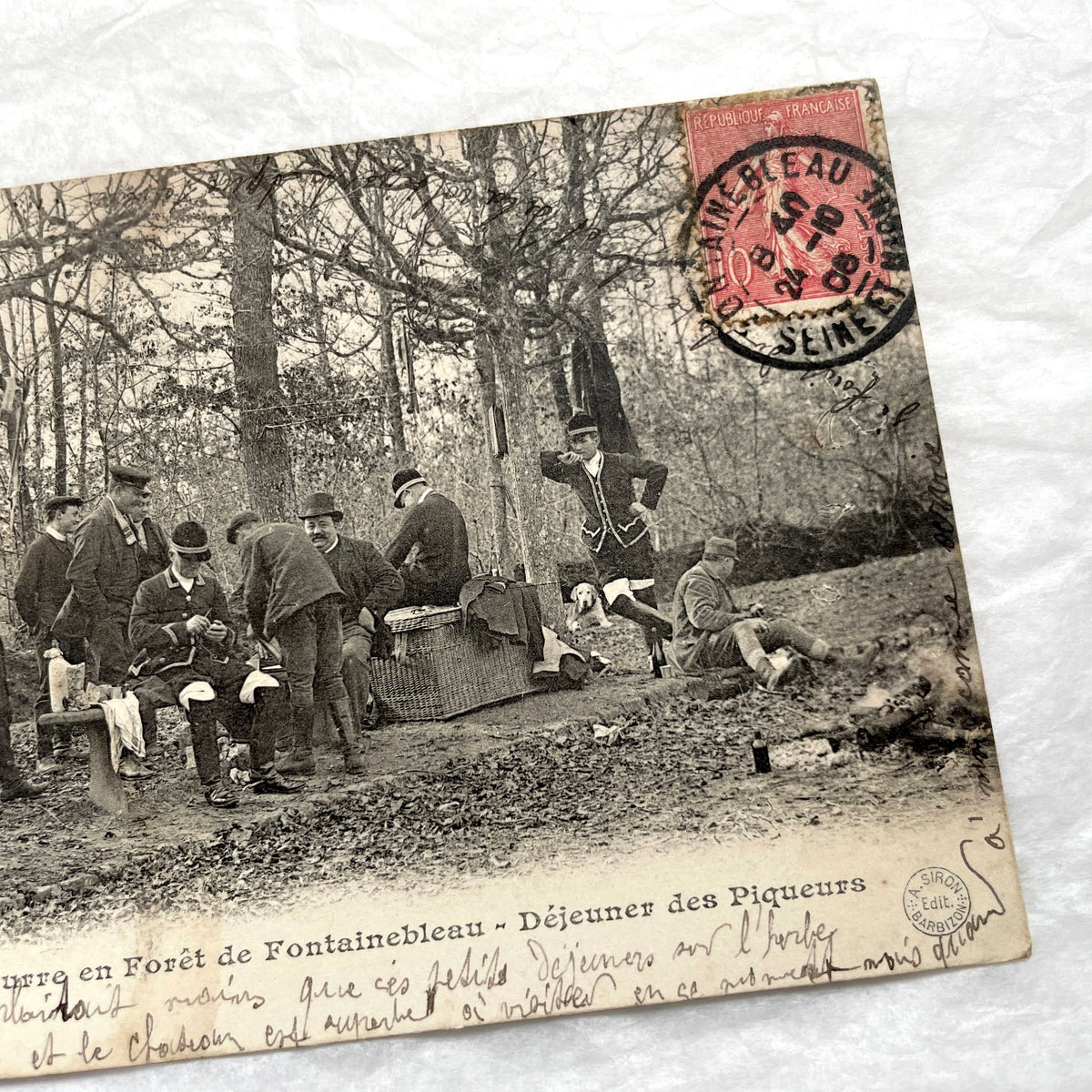 1900s French postcard showing huntsmen and a vintage bicycle having a picnic in Fontainebleau Forest.