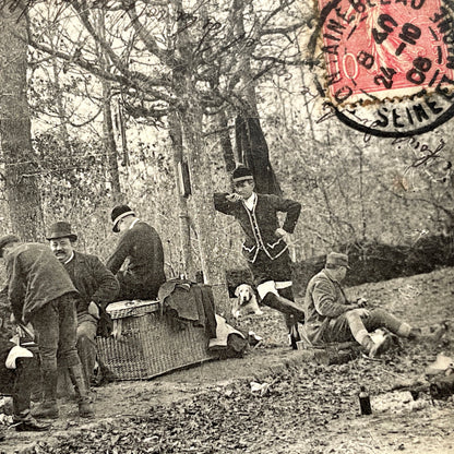 1900s French postcard showing huntsmen and a vintage bicycle having a picnic in Fontainebleau Forest.