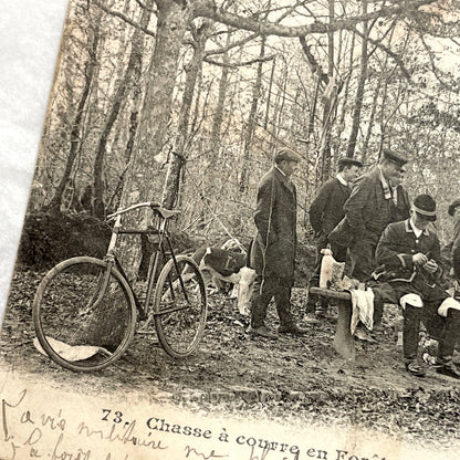 1900s French postcard showing huntsmen and a vintage bicycle having a picnic in Fontainebleau Forest.