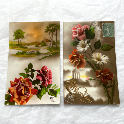 1910s French Postcard Lot featuring embossed floral designs with roses and daisies, and a peaceful village landscape.