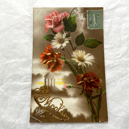 1910s French Postcard Lot featuring embossed floral designs with roses and daisies, and a peaceful village landscape.