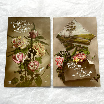 1910s French postcard lot with floral designs and a die-cut landscape scene of a village and church.